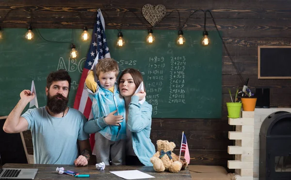 Playing concept. Family playing with paper planes in school. Little boy and teachers playing pilots in class. Playing games. — Stock Photo, Image