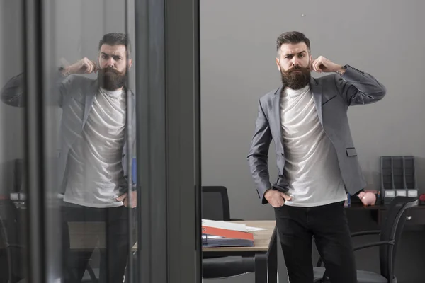 Hipster em escritório moderno com paredes de vidro. Hipster com barba e bigode em terno casual no local de trabalho, negócios e estilo de vida de escritório — Fotografia de Stock