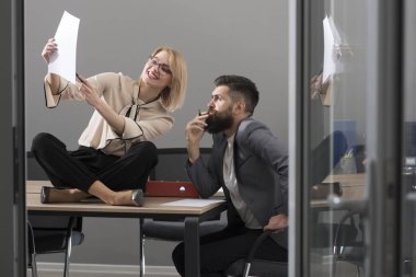 İş kadını ve işadamı iş planı yazmak. Başarı için işbirliği. Ofiste yoğun bir gün. Şehvetli kadın ve sakallı adam birlikte ofisinde çalışıyorum. Çalışmalarına konsantre