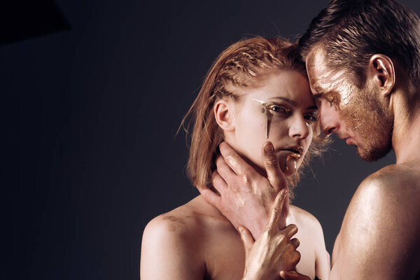 Эротические игры влюблённых пар. Сексуальная пара с золотым макияжем, копировальное пространство. Золотой спа и лечение кожи. Золотая маска и красота коллагена. 24K Gold. Мужские и женские отношения
