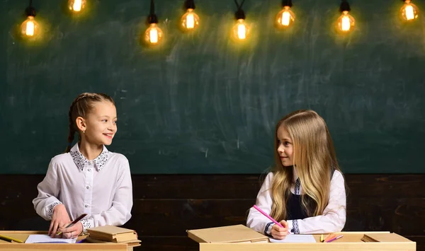 Skoltid. skoltid av två flicka friens på lektion. utgifter skola tid ihop. skoltid leende små flickor. — Stockfoto