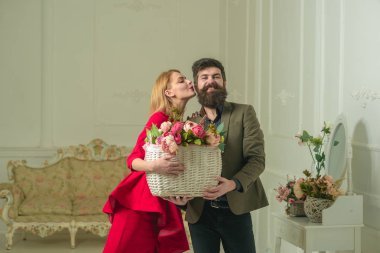 Sevgililer günü kavramı. Güzel kadın Sevgililer günü çiçek sepeti yakışıklı adam öpücük. Şehvetli kadın ve sakallı adam taze çiçek Sevgililer günü tutun. Mutlu sevgililer günü