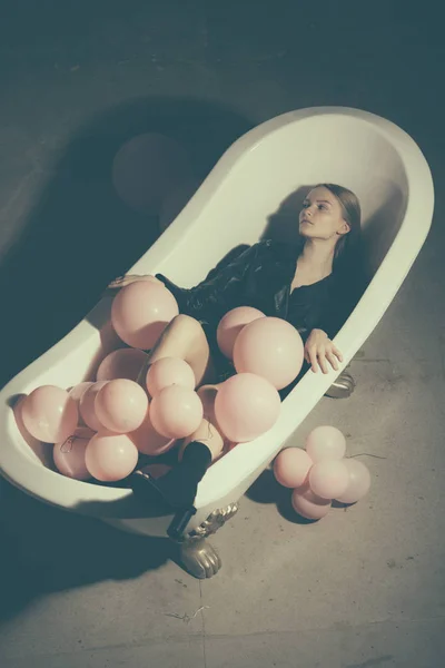Modelo de moda en abrigo de otoño. mujer relajarse en el baño. globos de fiesta en la bañera de burbujas. higiene y tratamiento de spa. divertirse en el baño. Concepto de inspiración y bienestar. salud y belleza . —  Fotos de Stock