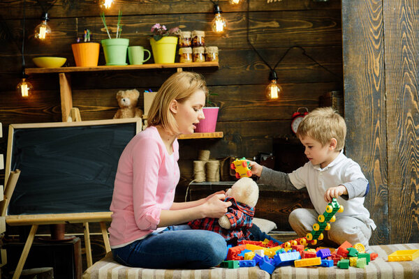 Концепция детской школы. Детка из детского сада играет с мамой. Детские игры. Детское образование и уход за детьми
