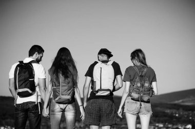 Dağın tepesinde mavi gökyüzü üzerinde pastoral manzara izlerken arkadaşlar