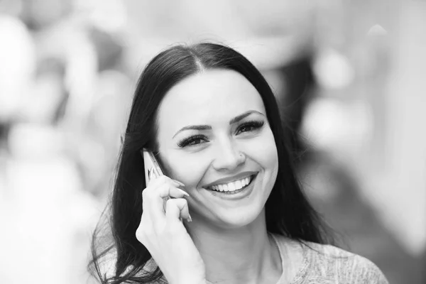 happy brunette girl speaking on mobile or cell phone outdoor