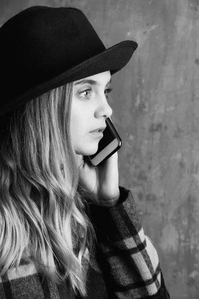 Affascinante giovane donna in cappello parlando sul cellulare — Foto Stock