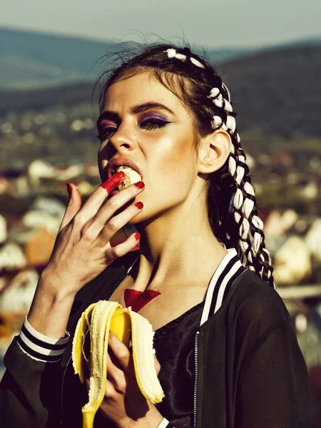 Jovem mulher comer banana ensolarado ao ar livre — Fotografia de Stock
