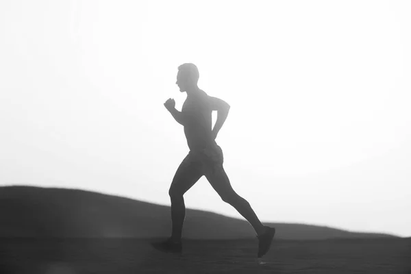 A naplementében dűne futó ember runner — Stock Fotó
