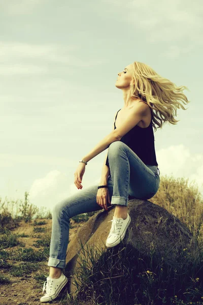 Jolie femme sur pierre et ciel bleu — Photo