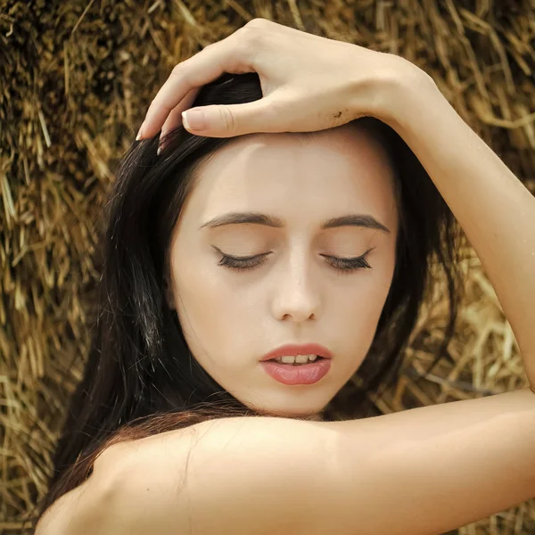 Девушка с брюнетками позирует в сене — стоковое фото