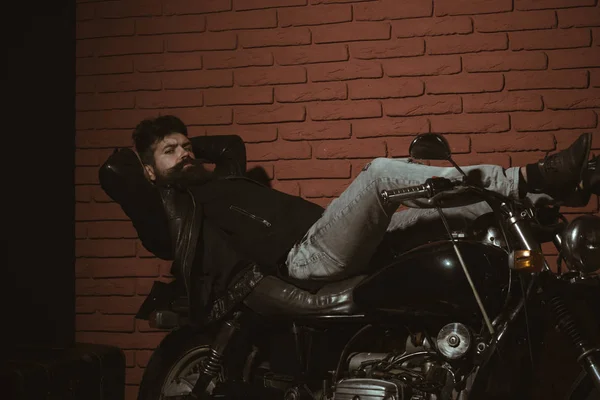 Hipster on motorbike. bearded hipster on motorbike. hipster on motorbike in leather jacket. hipster on motorbike having relax time. man in motor garage. — Stock Photo, Image