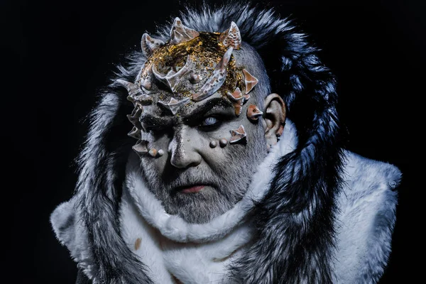 Dark arts concept. Senior man with white beard dressed like monster. Demon on black background, close up. Man with thorns or warts in fur coat. Alien, demon, sorcerer makeup. — Stock Photo, Image