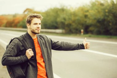 Genç adam otostop çekiyor.