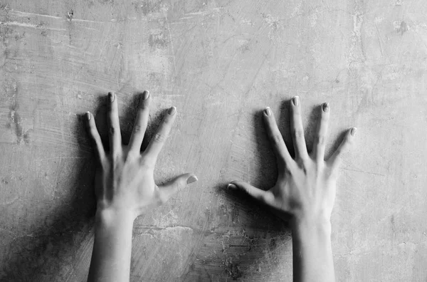 Dvojice ženské ruce na zeď abstraktní cementu — Stock fotografie