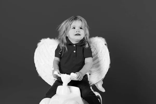 Ангел маленький мальчик на красном фоне на автомобильной игрушке — стоковое фото