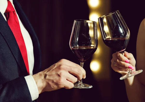 乾杯は、カップル チャリンという音の赤ワインのガラス — ストック写真