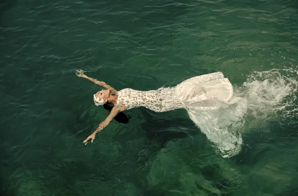 Panna młoda kobieta kąpiel w suknię ślubną białą w wodzie morskiej — Zdjęcie stockowe