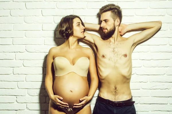 Barbudo delgado hombre y bonita mujer embarazada con vientre redondo —  Fotos de Stock