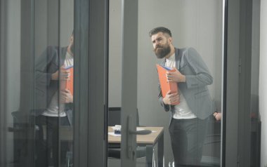 Toplantı salonunun içinde mali rapor tutan ciddi yakışıklı iş adamı