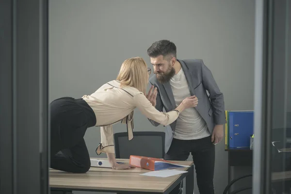 Girl on desktop seduce man in office. Girl dominating man at workplace, matriarchy