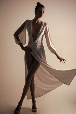 Kadın esmer saçlı ve kırmızı dudaklar. Güzellik ve moda. Görünüm ve moda stil... Moda model poz Studio gri arka plan üzerinde. Beyaz şık elbiseli kız.