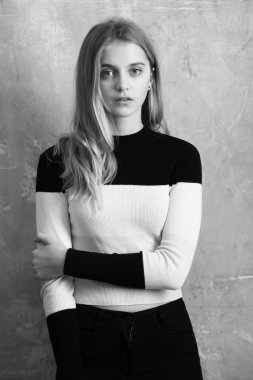 güzel genç kız pantolon ve jersey duvar arka plan üzerinde