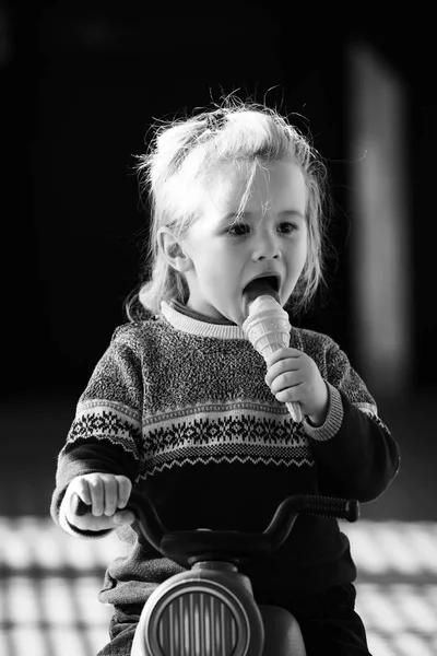 Kind oder kleiner Junge isst Eis auf Spielzeugfahrrad — Stockfoto