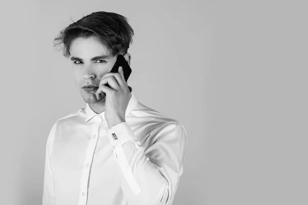 Красивий чоловік у білій сорочці з манжетом, що говорить по телефону — стокове фото