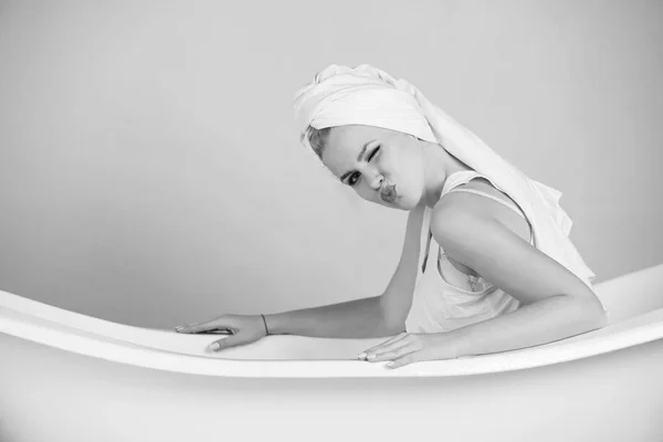 Mulher muito sexy com turbante toalha sentado na banheira branca — Fotografia de Stock