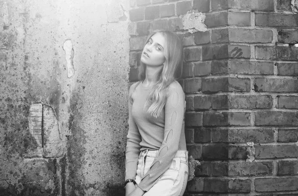 Chica con estilo cerca de ladrillo pared texturizada, belleza y moda — Foto de Stock