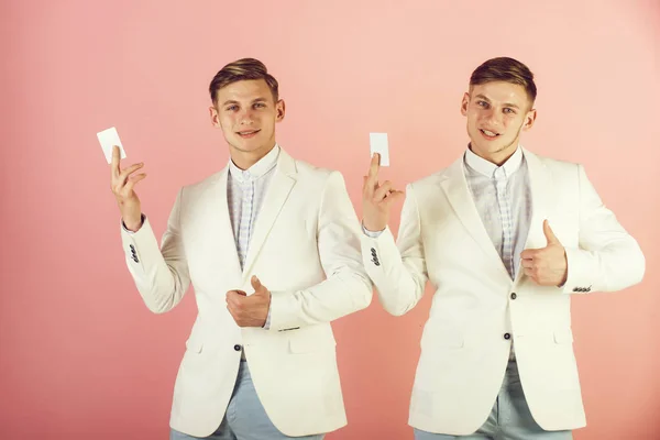 Men showing thumbs up with blank cards on pink background