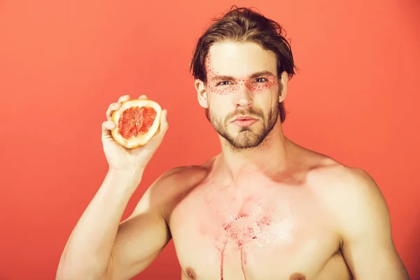 man with creative fashionable makeup hold grapefruit, vitamin