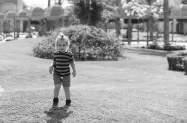 Yeşil çimenlerin üzerinde oynarken mutlu sevimli bebek çocuk