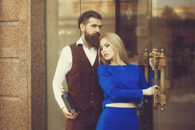 Şişe cam kapı şarap kucaklama kız ile erkek arkadaşı. Kadın veya kız açık havada tuğla duvar üzerinde mavi elbise ve adam hipster içinde. Alkol ve convive. İki aşık. Sağlıksız yaşam tarzı. Kötü alışkanlıkları