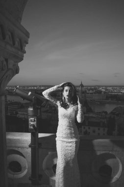 Teleskop üzerinde cityscape bakış açısı olan kadın. Beyaz gelinlik, moda uzun saçlı kadın
