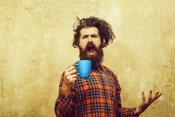 Cantando barbudo hombre tirando elegante flequillo cabello con azul taza —  Fotos de Stock