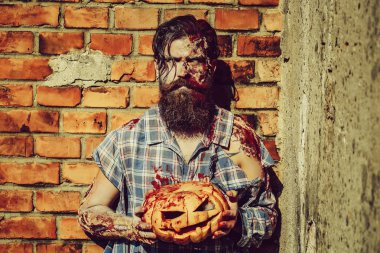 Sakallı zombi adamla sakal Cadılar Bayramı vampir ya da yaralar olan kanlı savaş asker ve kabak tuğla duvar ile kırmızı kan
