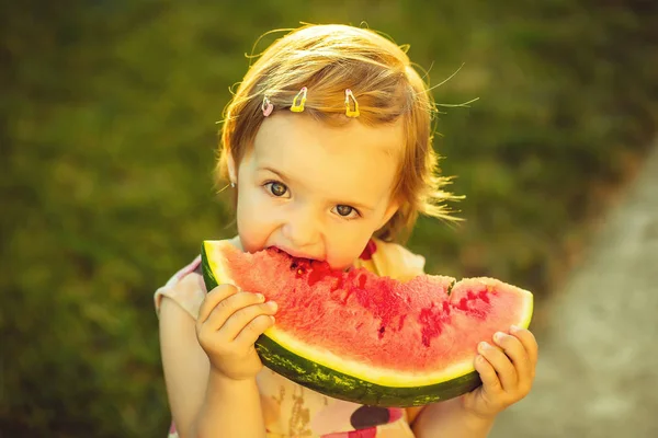 Flicka äter röd vattenmelon utomhus — Stockfoto