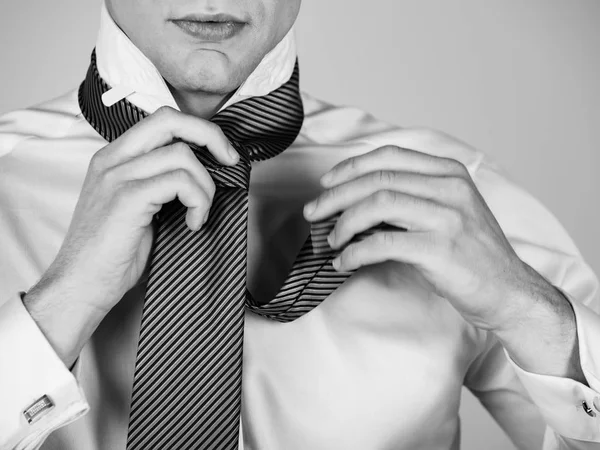 Hombre atando una corbata a rayas en camisa blanca — Foto de Stock