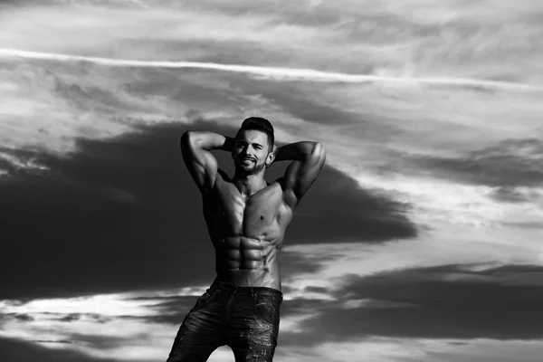Hombre atleta feliz con el cuerpo muscular en el cielo azul — Foto de Stock