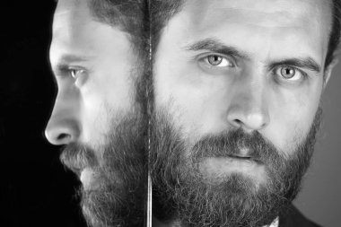 ciddi sakallı hippi adamın, aynada yansıtan işadamı yüzü