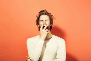 uzun uncombed saçlı, sabah uyanmak uykulu esneme adam