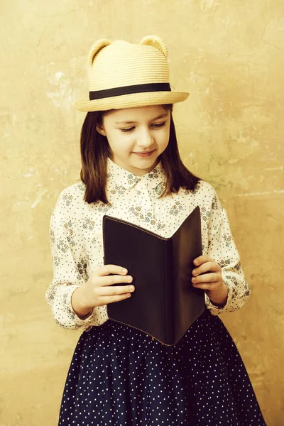 可爱的小女孩阅读黑色笔记本 — 图库照片