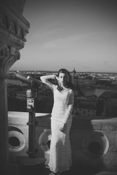 Mulher de moda de casamento com telescópio em miradouro em paisagem urbana. Moda modelo de viagem de férias, casamento — Fotografia de Stock