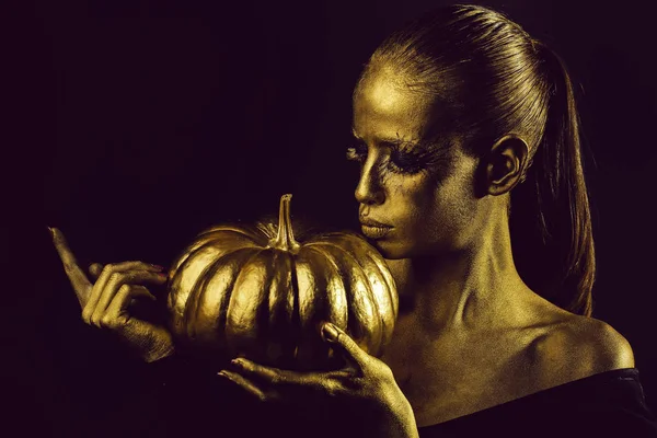 Mujer dorada con calabaza de halloween —  Fotos de Stock