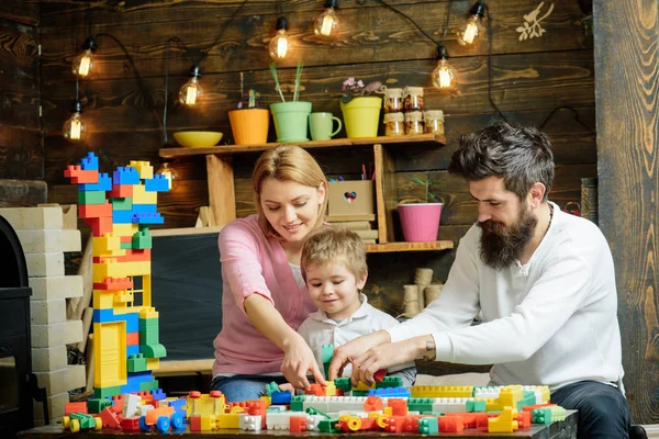 Konstrukční koncepce. Malé dítě s matkou a otec hrát s hračkou stavebnice. Rodinu stavět model struktury s stavebnice. Stavba domu snů — Stock fotografie