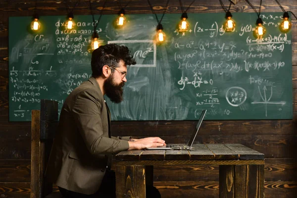 Professora de óculos lendo relatos de alunos talentosos corrigindo erros, Retrato de professora usando laptop de tecnologia moderna em sua classe , — Fotografia de Stock