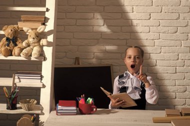 Kız öğrenci yazı tahtası yakınındaki açık kitap fikri vardır