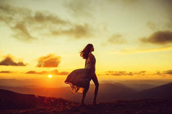 Mulher ao pôr-do-sol ou nascer do sol nas montanhas — Fotografia de Stock